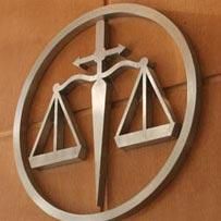 Una balanza de la justicia con una cruz en un círculo en una pared.