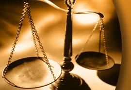 Un primer plano de una balanza de la justicia sobre una mesa.