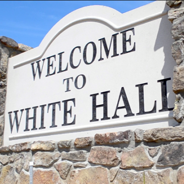 A stone wall with a sign that says welcome to white hall. Southern Caregivers in White Hall. Caregivers in Pine Bluff
