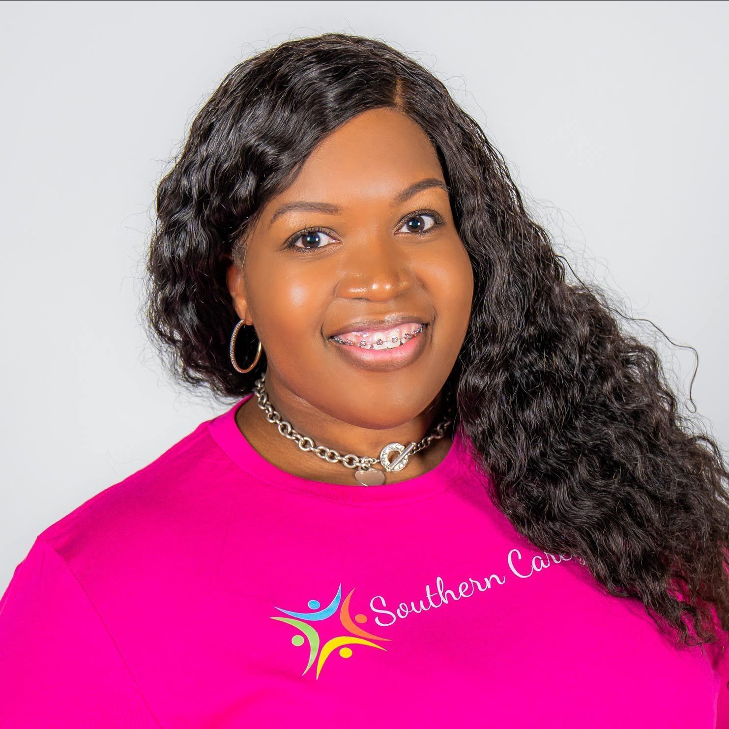 A woman wearing a pink shirt with the word southern caregivers on it