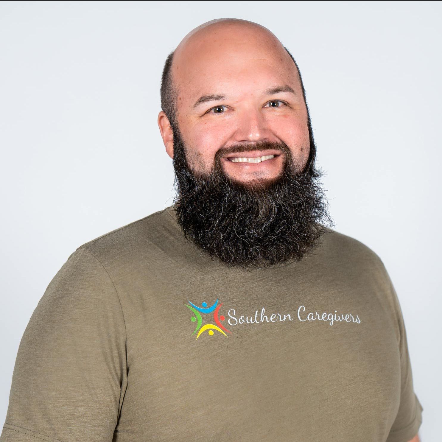 A man with a beard is wearing a southern caregivers t-shirt