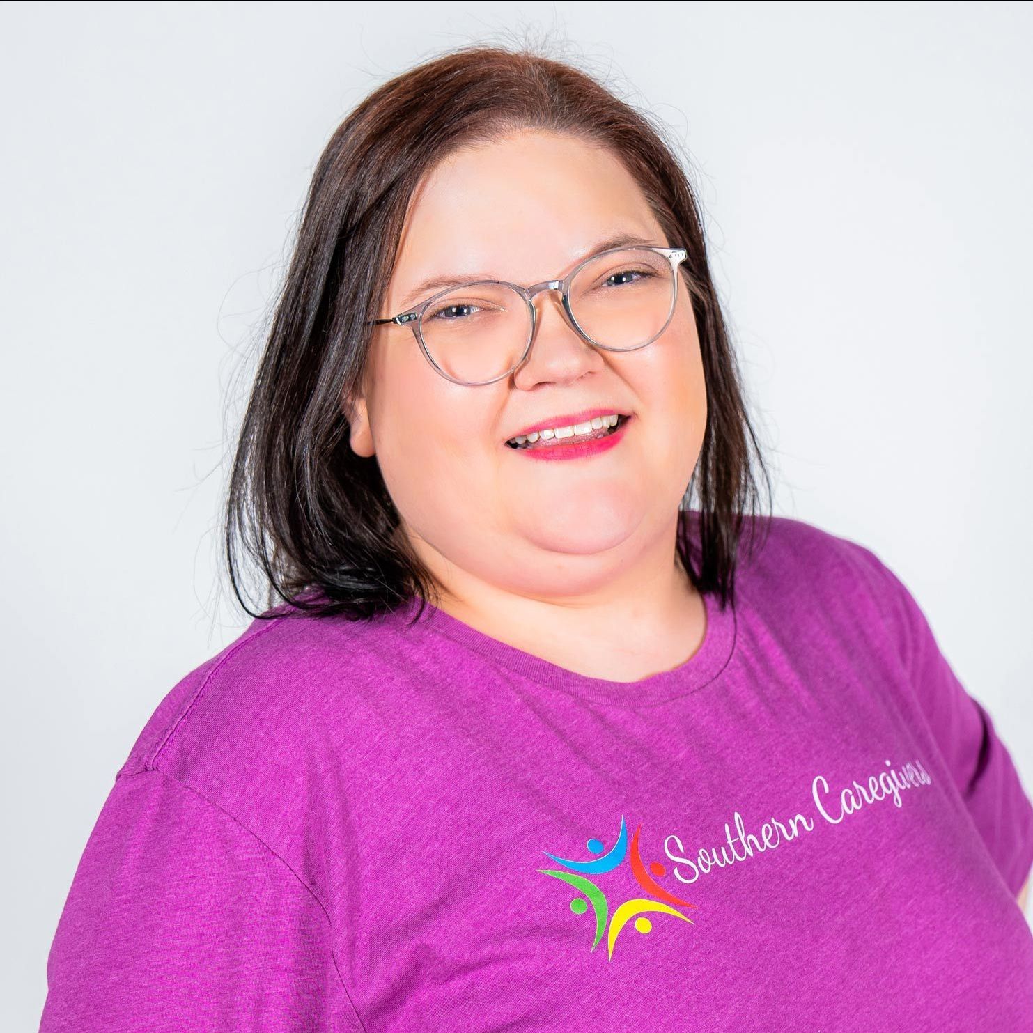 A woman wearing glasses and a purple shirt that says southern caregivers