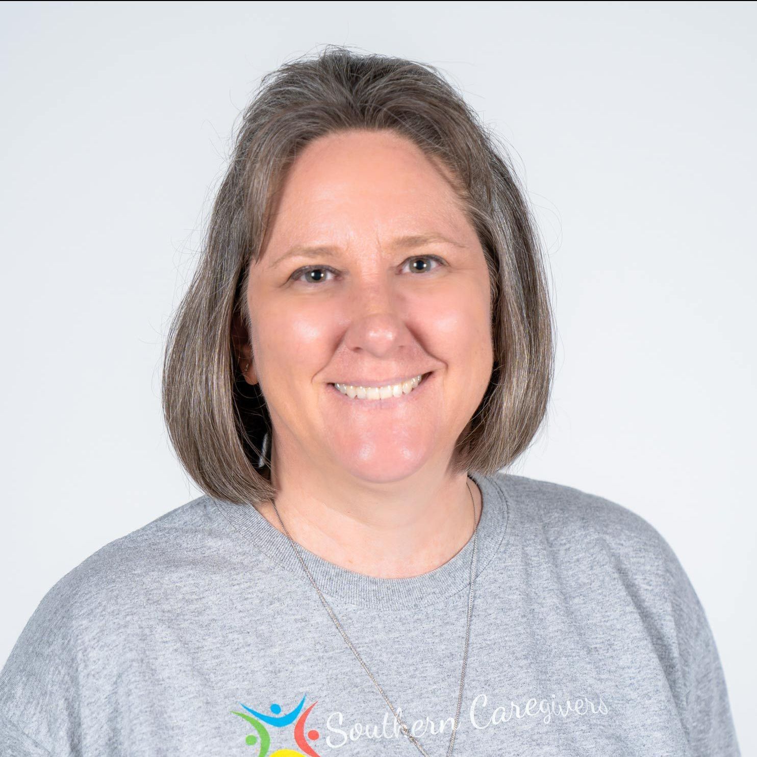 A woman wearing a grey shirt that says southern caregivers smiles for the camera