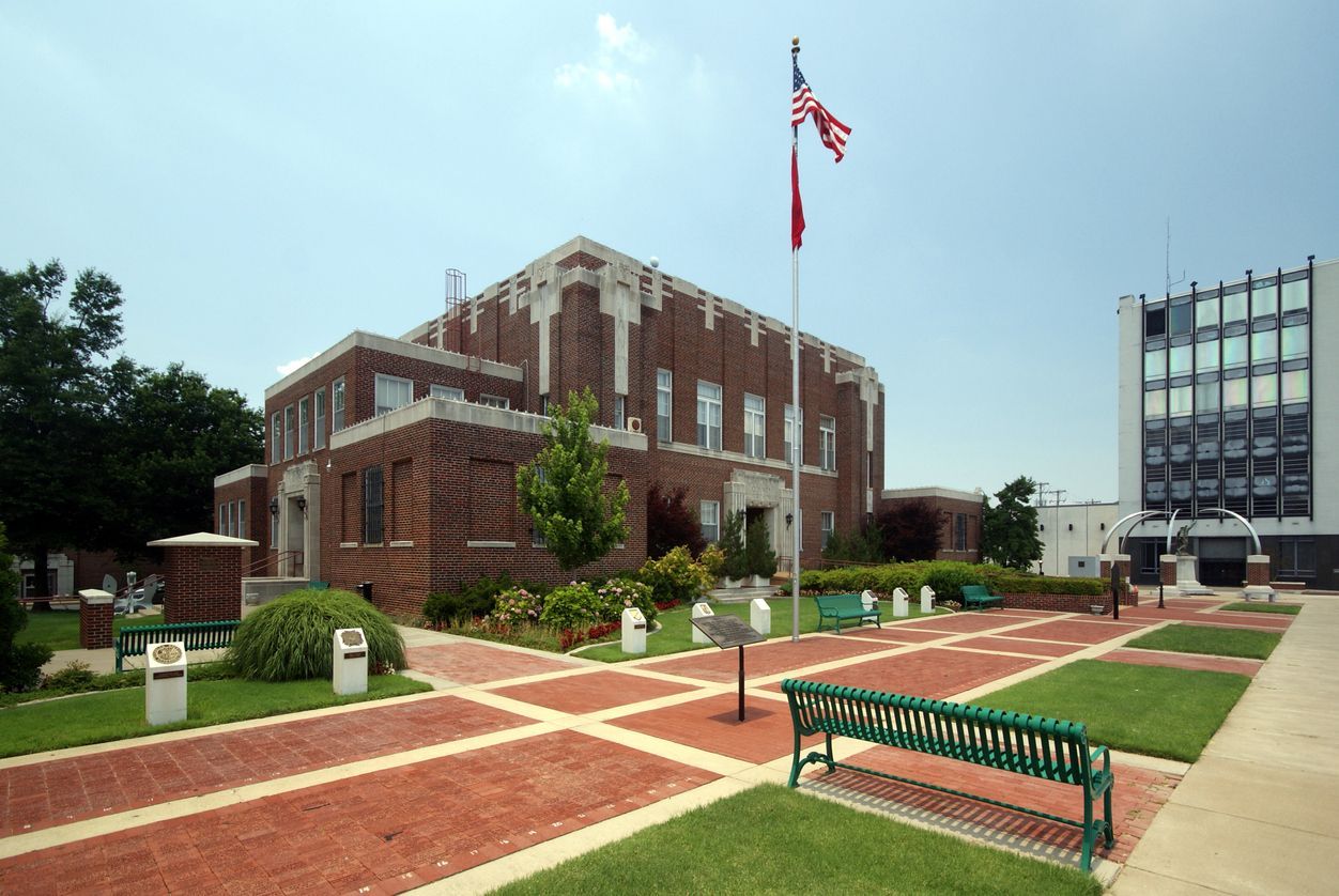 A brick building with an american flag flying in front of it. Southern Caregivers building in Jonesboro, AR.