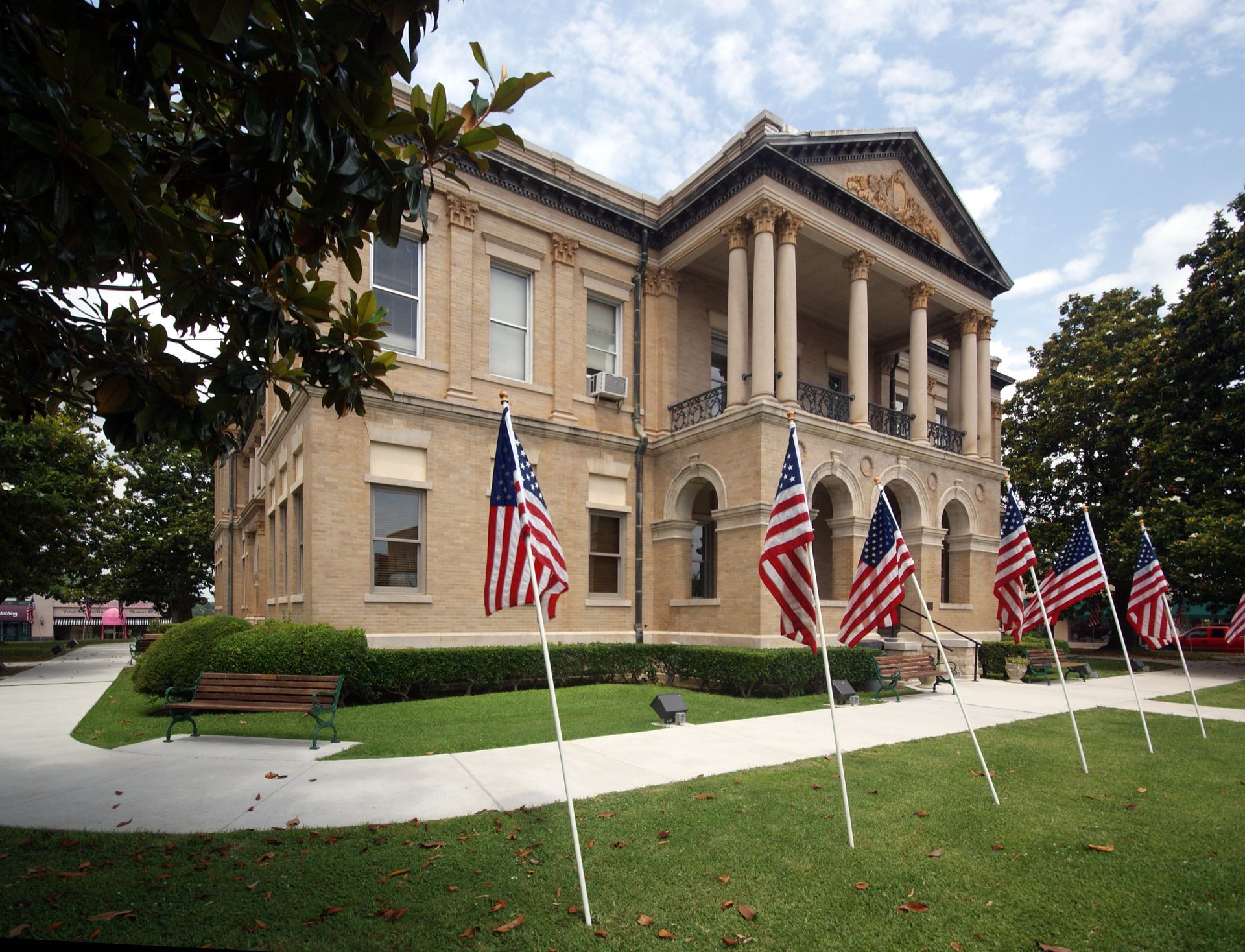 Several american flags are displayed in front of a large building. Southern Caregivers building in Magnolia, AR.