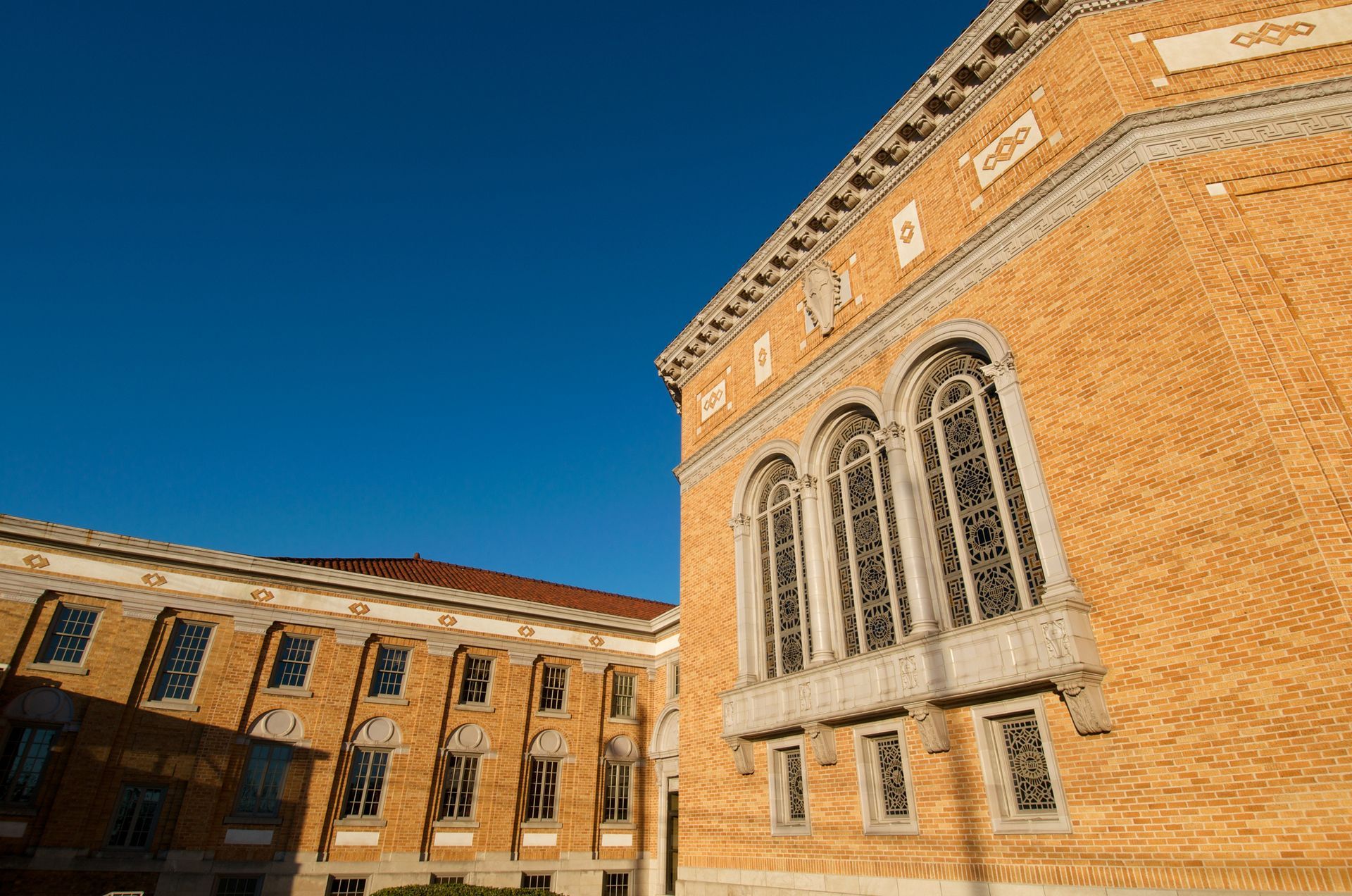 Busy street scene with cars and a church in the background. Traffic lights are red, and overcast sky.