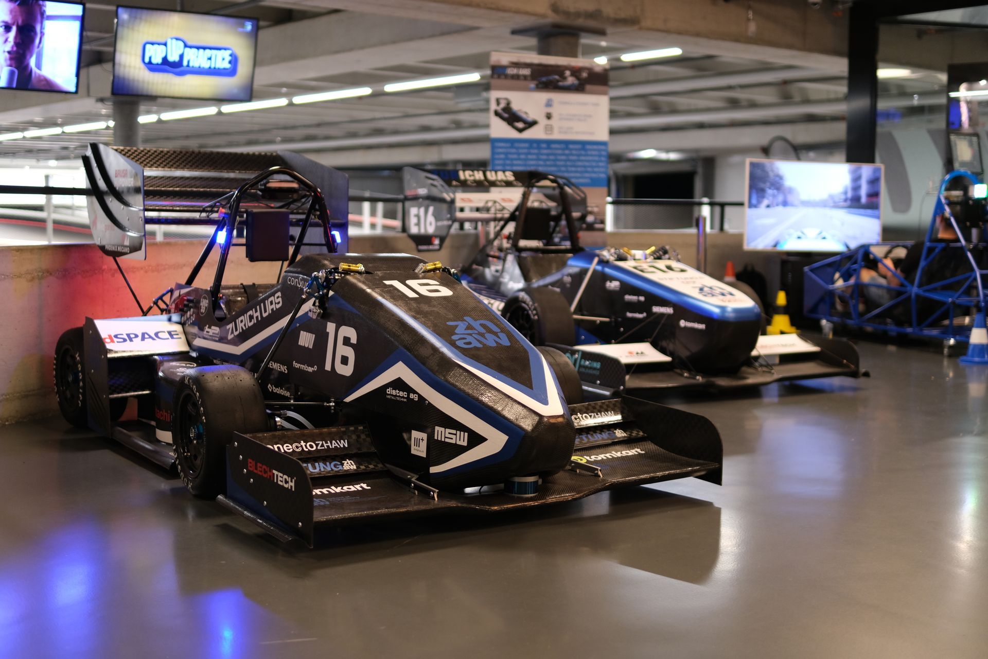 In einem Raum ist eine Reihe von Rennwagen geparkt.