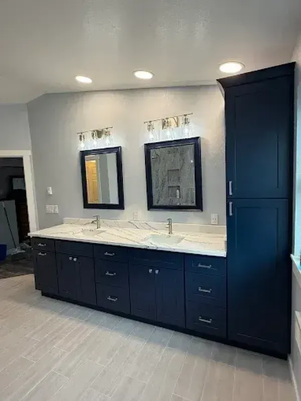 Bathroom with white tub, toilet, and light-colored tiled floor, viewed from doorway.