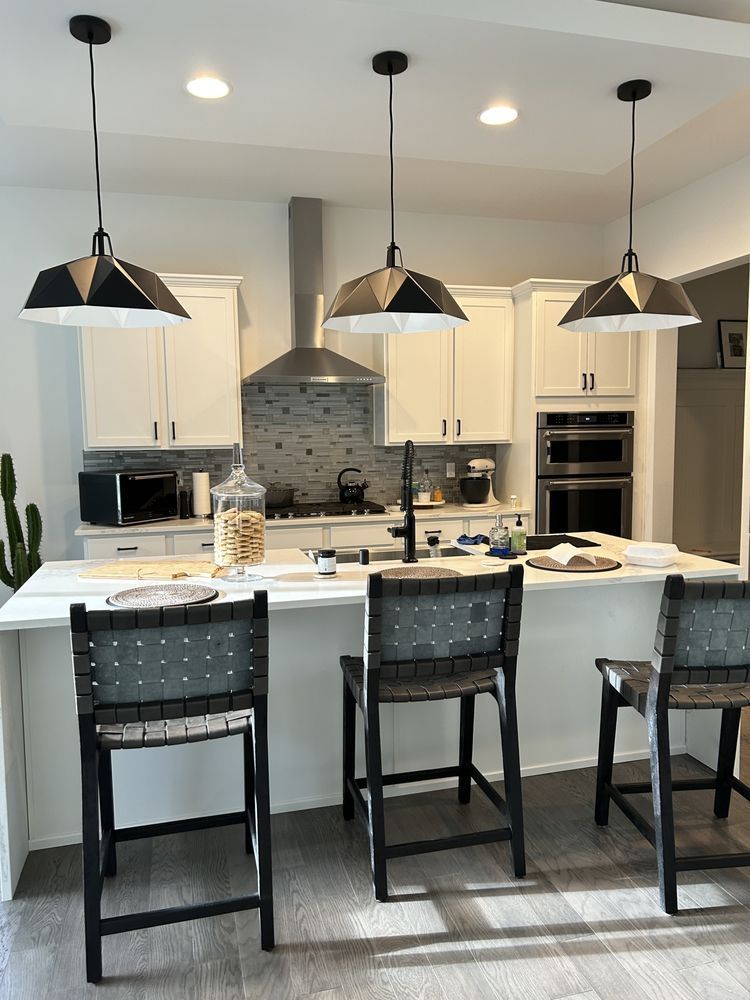 A wooden deck with a black metal railing and a wooden fence in the background.