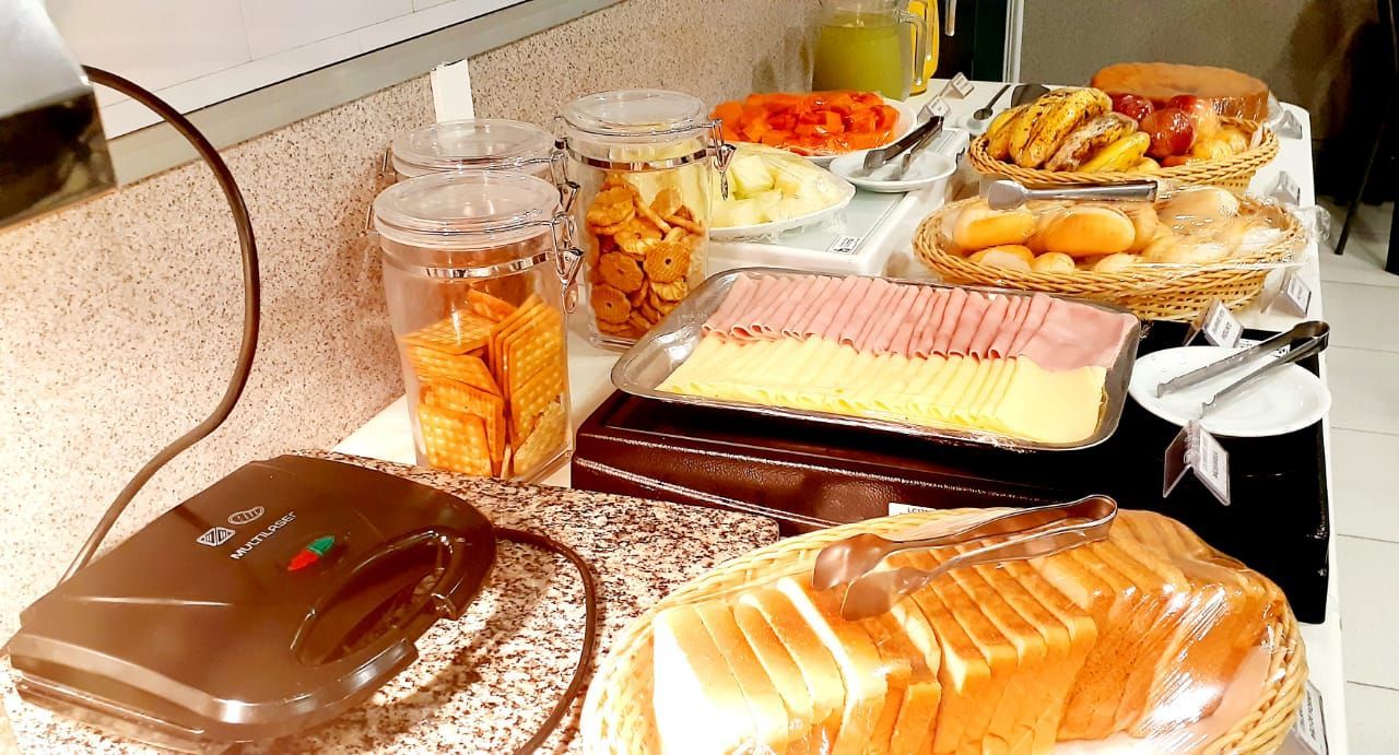 Uma mesa coberta com uma variedade de alimentos e uma sanduicheira.