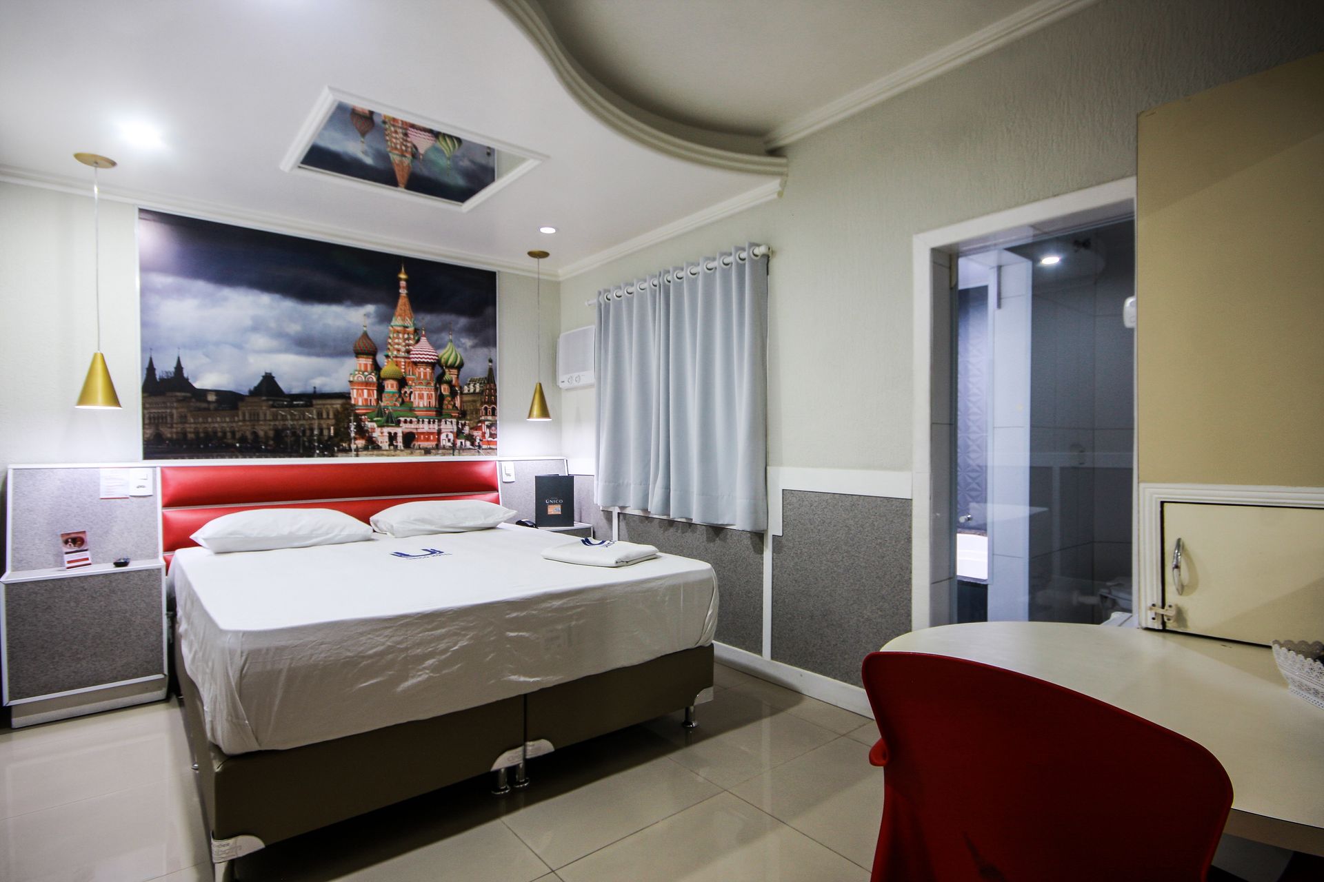 Um quarto de hotel com uma cama grande e um quadro na parede.