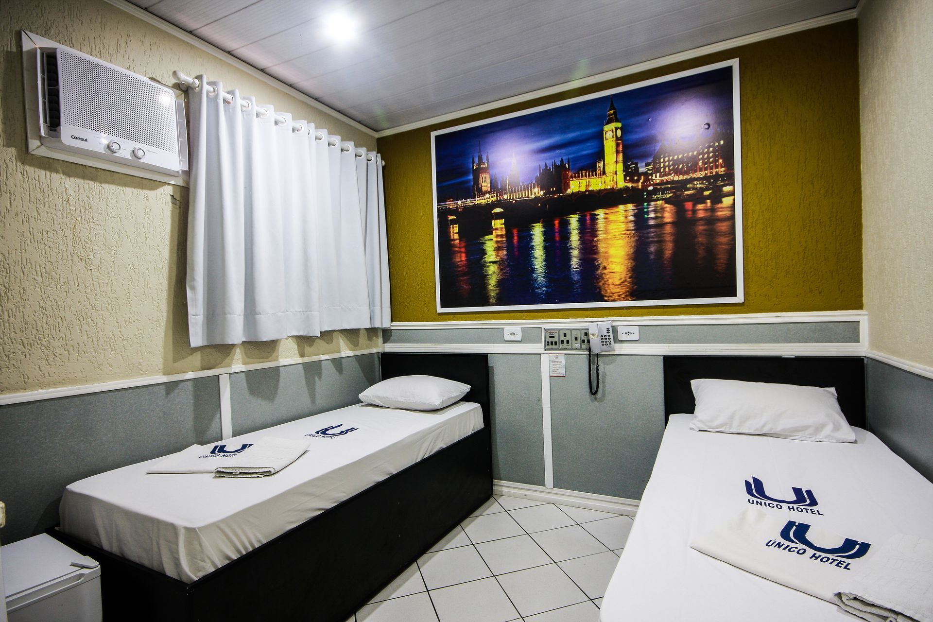 Um quarto de hotel com duas camas e uma foto na parede