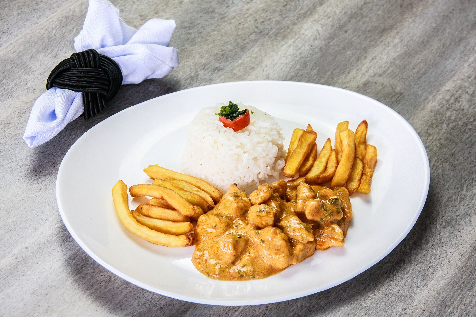 Um prato de comida com arroz e batatas fritas em uma mesa.