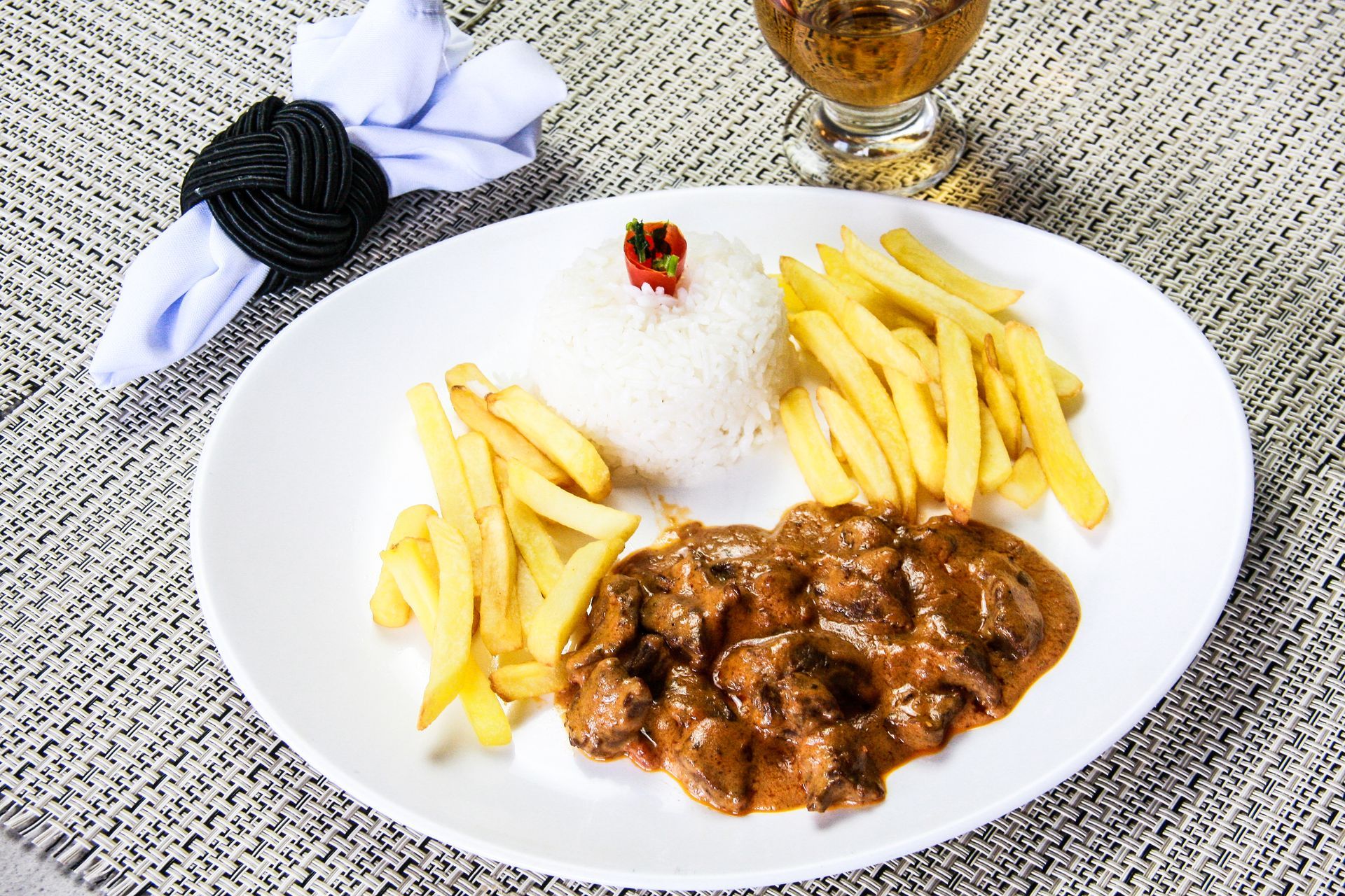 Um prato de comida com arroz e batatas fritas em uma mesa.