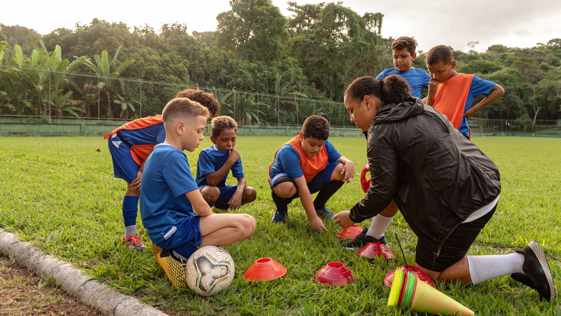 Coach teaching her youth soccer team a drill.