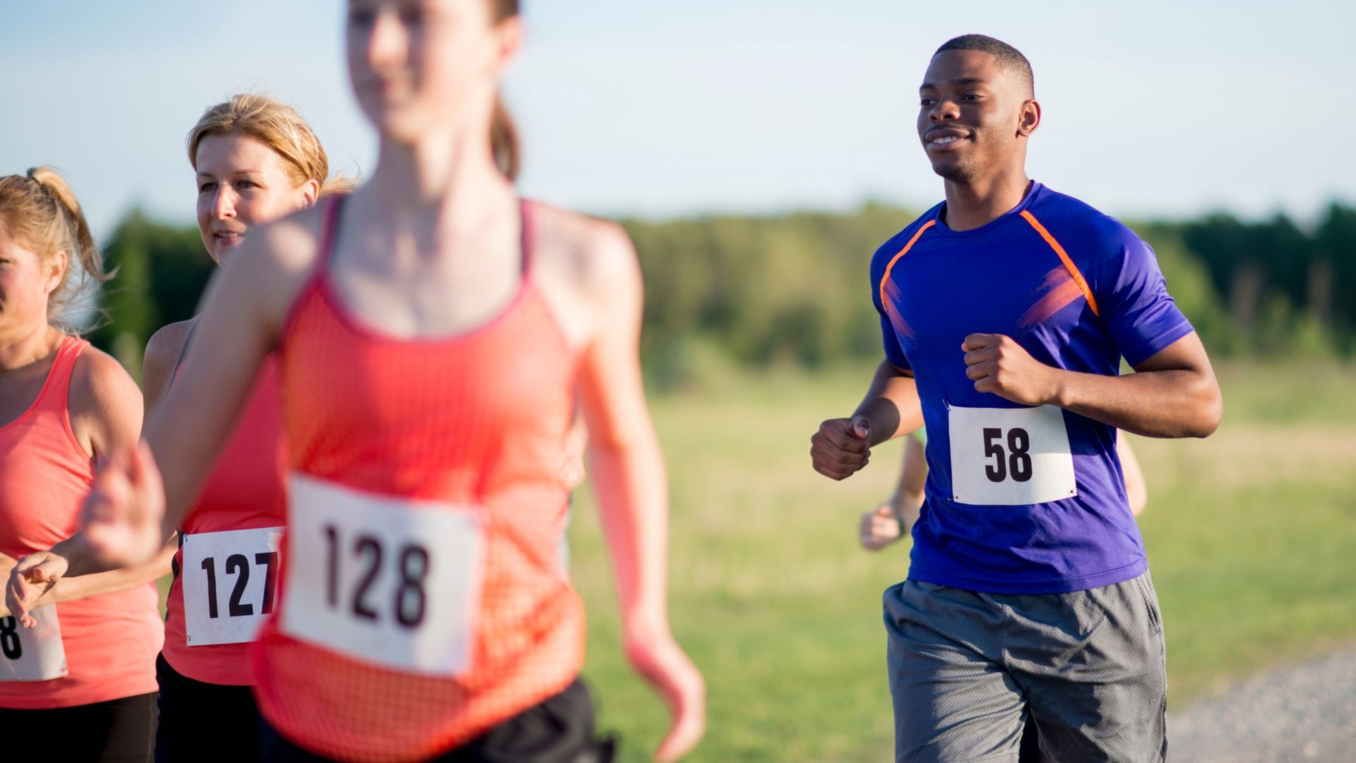 Four athletes running a five kilometer race in nature.