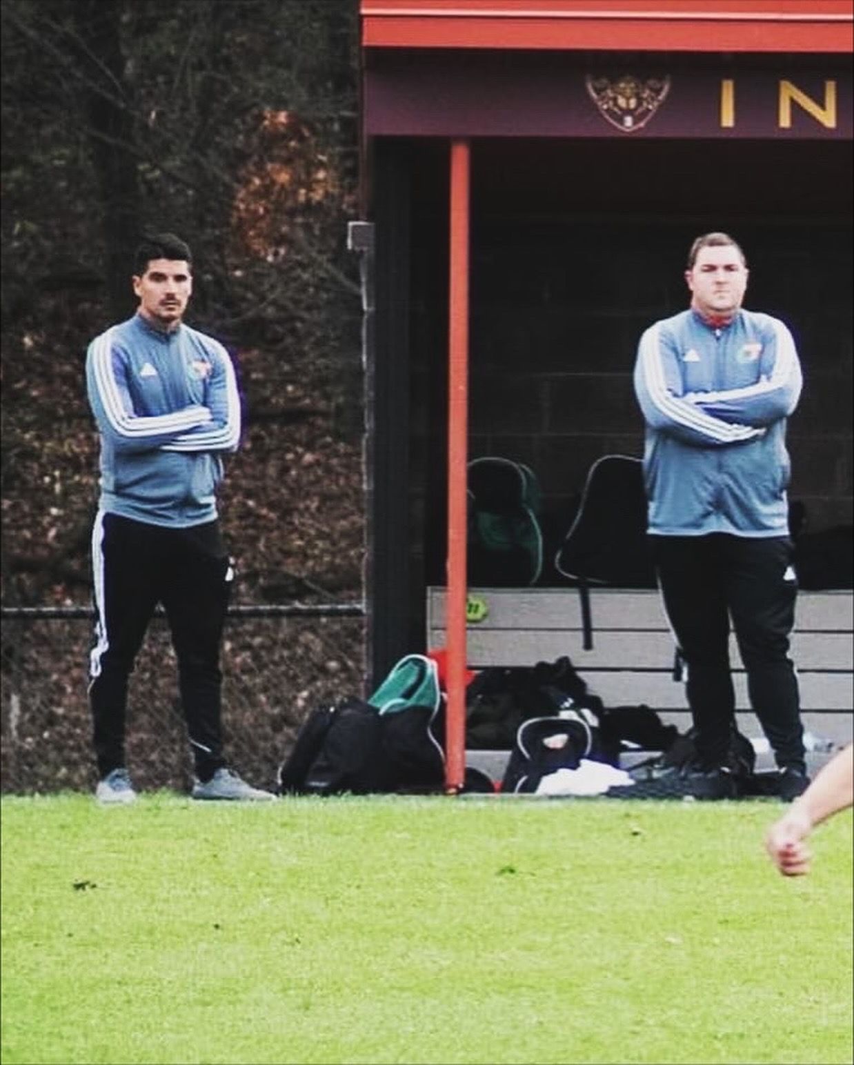 Joseph watching his team's match on the sideline with another coach.