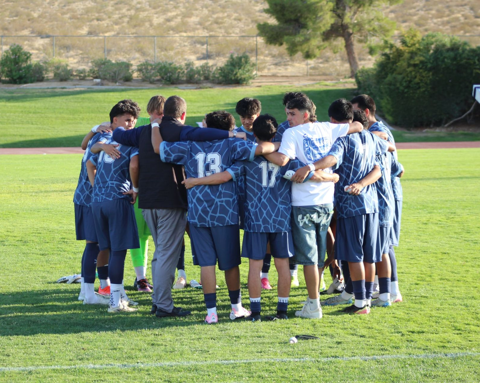Joe and his players huddled around in a circle.
