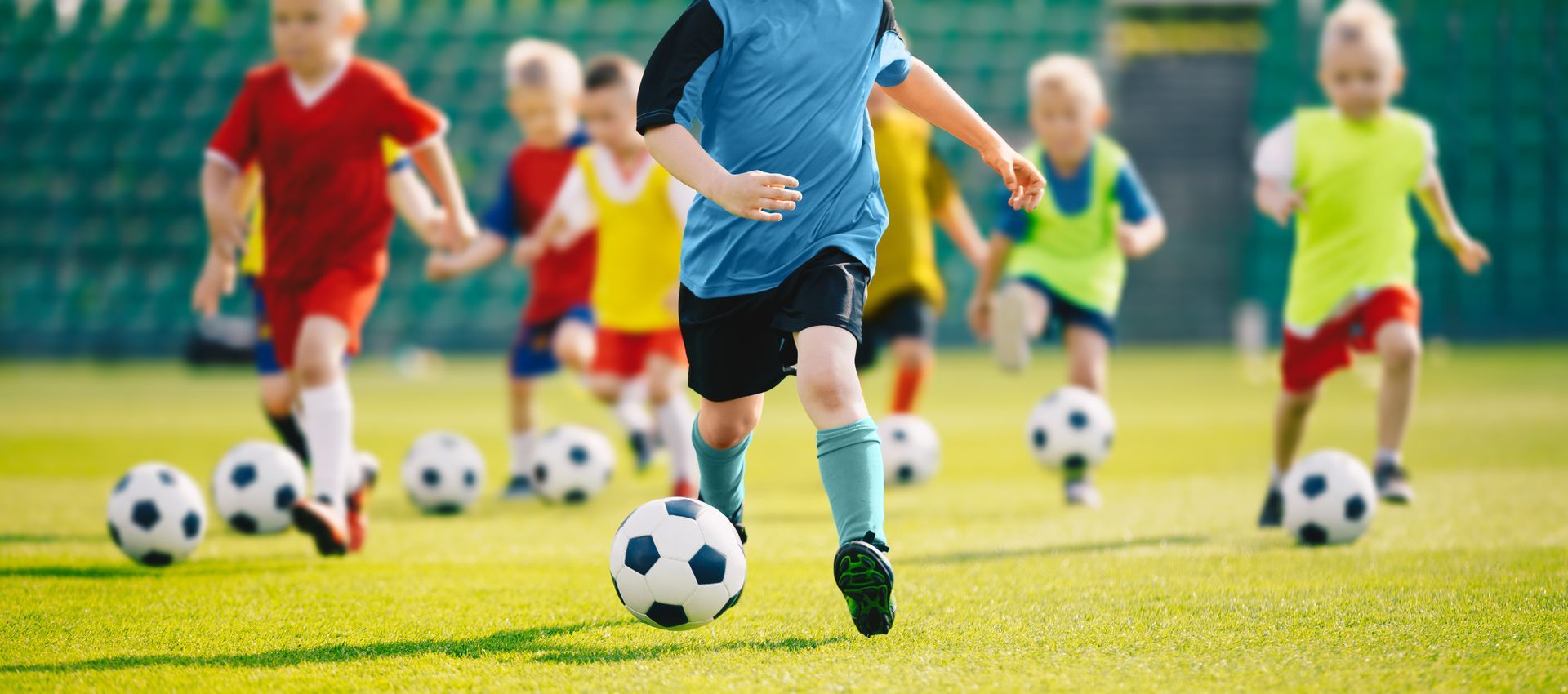 Youth soccer team dribbling in same direction on the field.