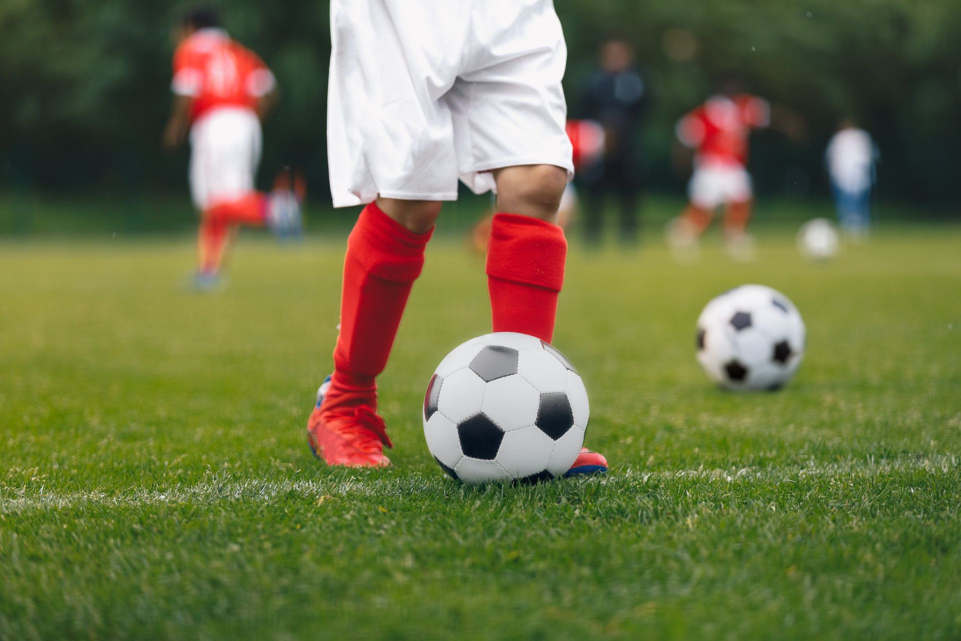 Young soccer player with ball in front of them.