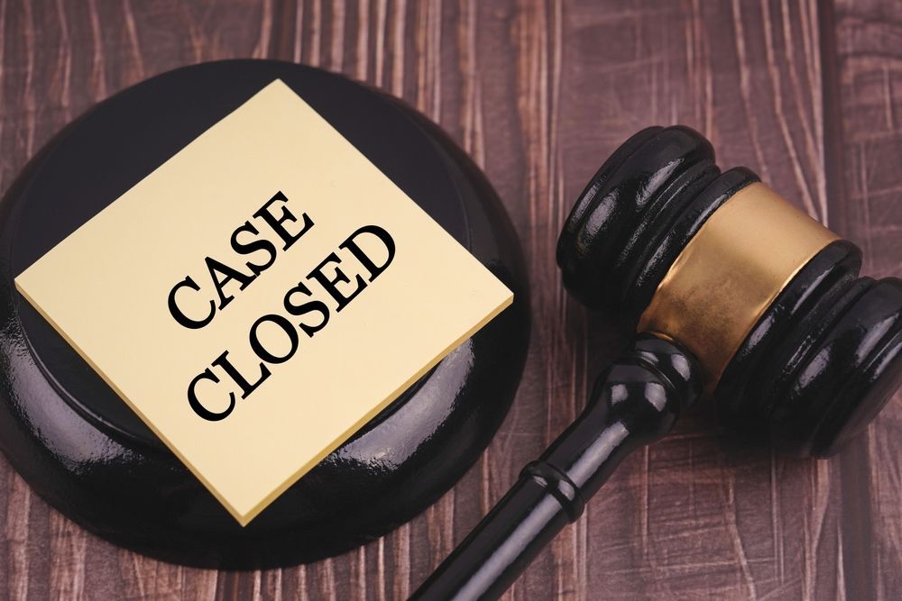 Gavel next to a black stand with a yellow sticky note that reads 