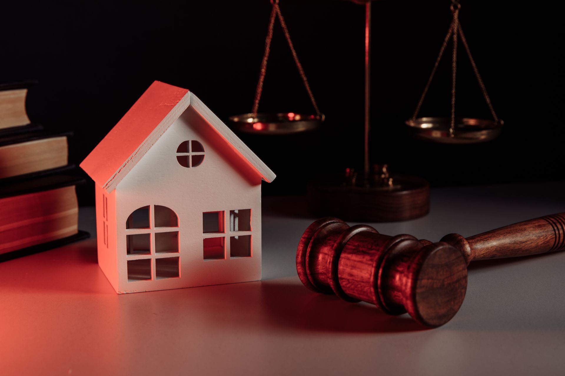 Miniature house, scales of justice, and gavel, representing real estate law.