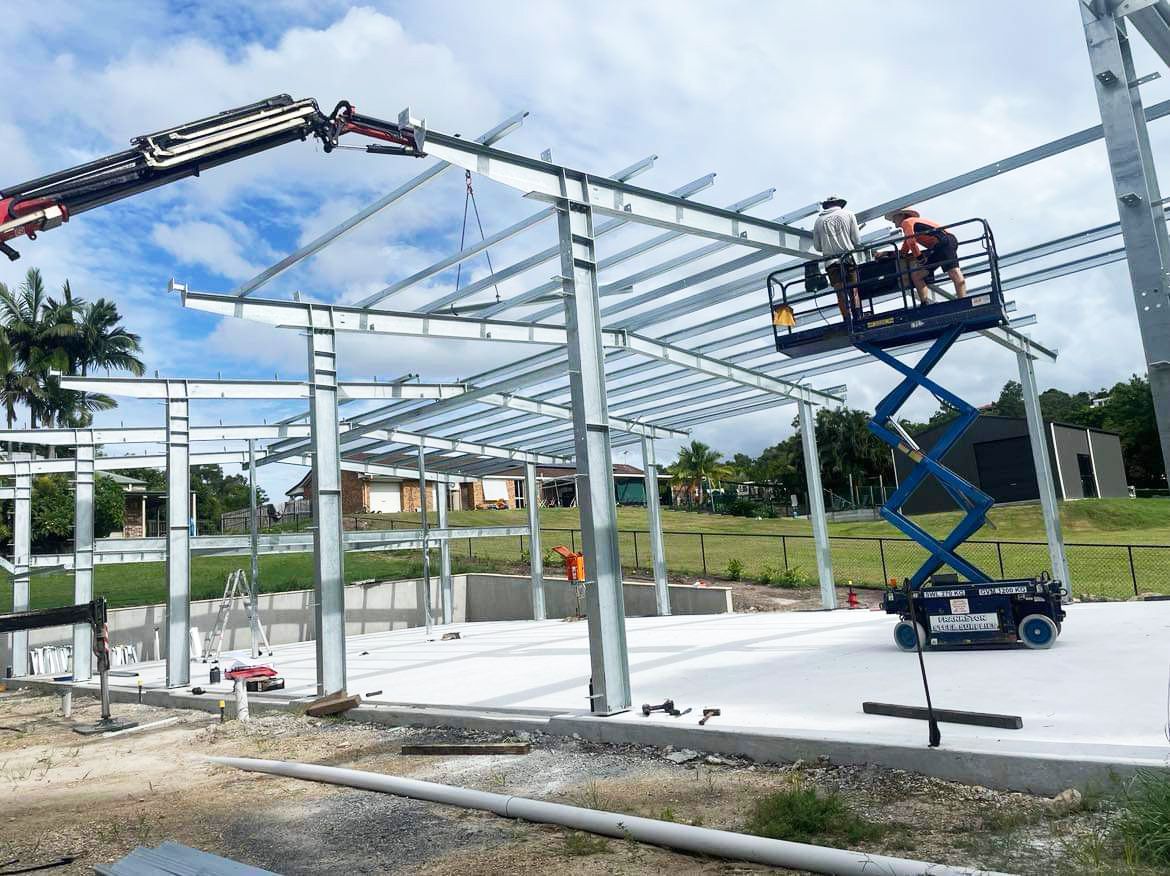 A construction site with a crane and a scissor lift.