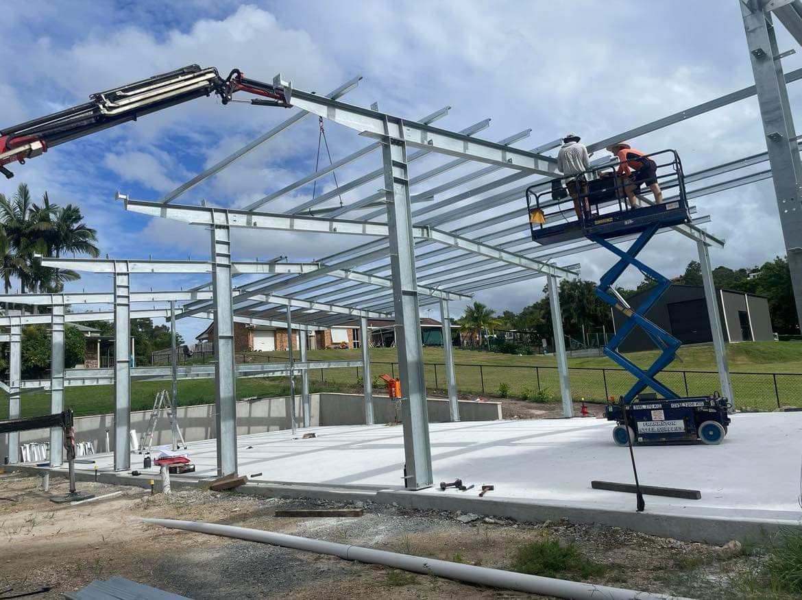 A group of construction workers are working on a large metal structure.