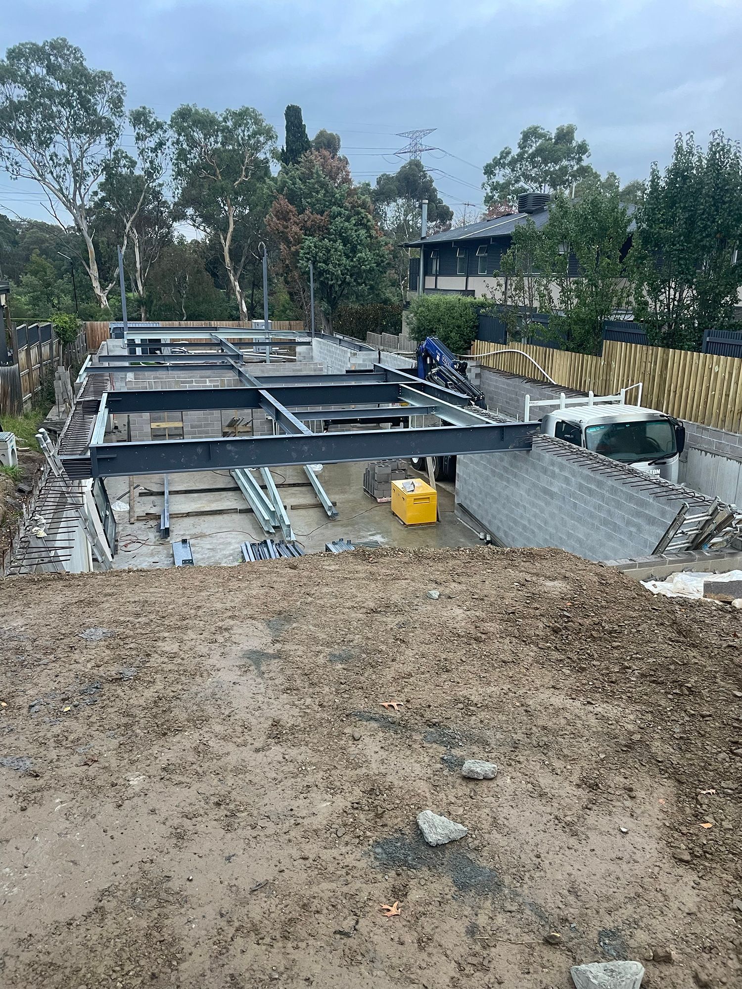 A construction site with a lot of dirt and trees in the background.