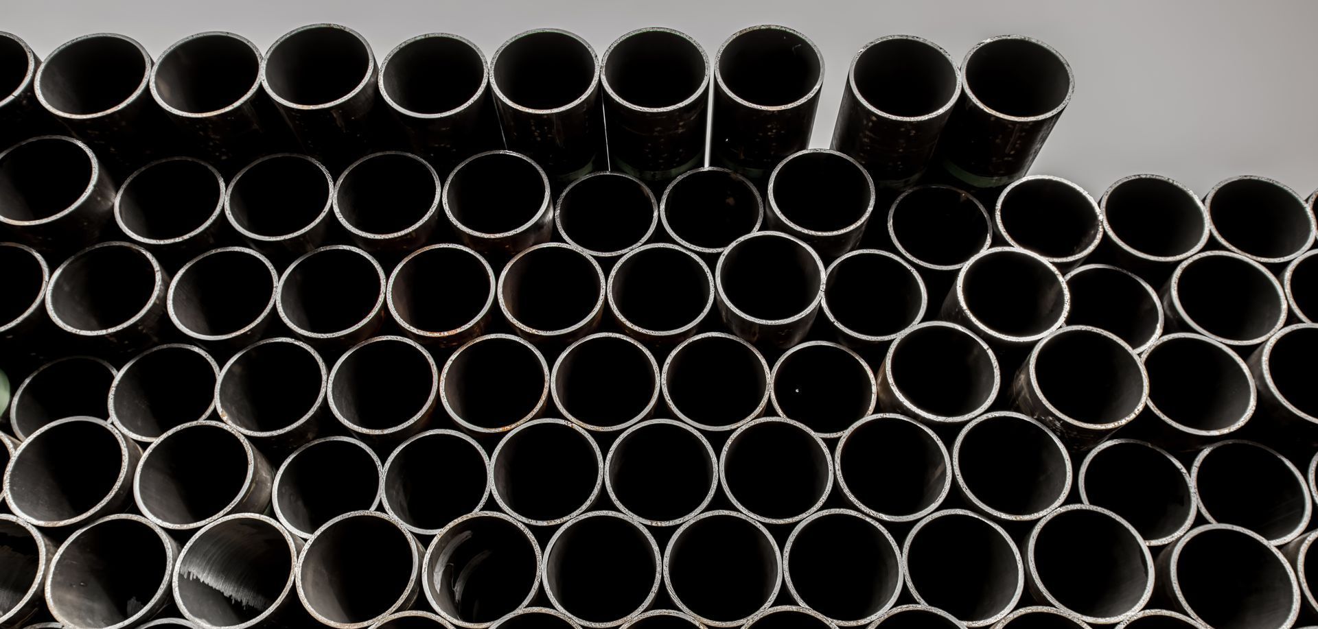 A bunch of metal pipes are stacked on top of each other.