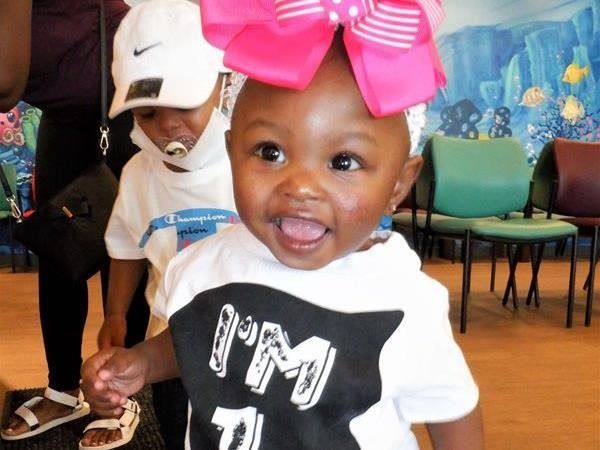 Smiling baby with a pink bow and 