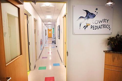 Hallway of Lowry Pediatrics office with colorful floor tiles and a shark logo.