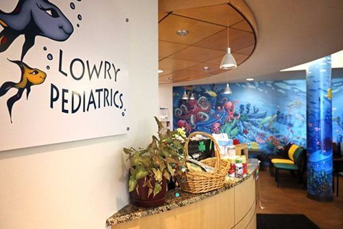 Reception area of Lowry Pediatrics with underwater mural and fish art.