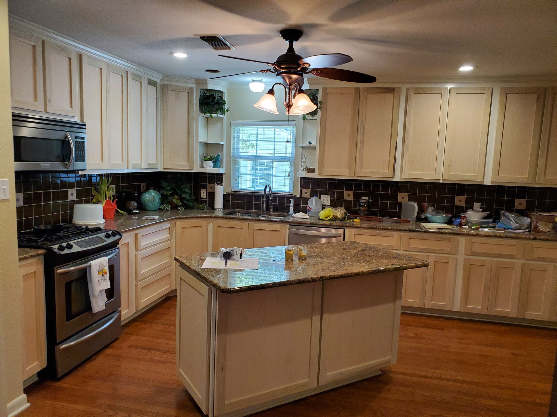 Cream-colored kitchen with stainless steel appliances, dark countertops, and a central island.