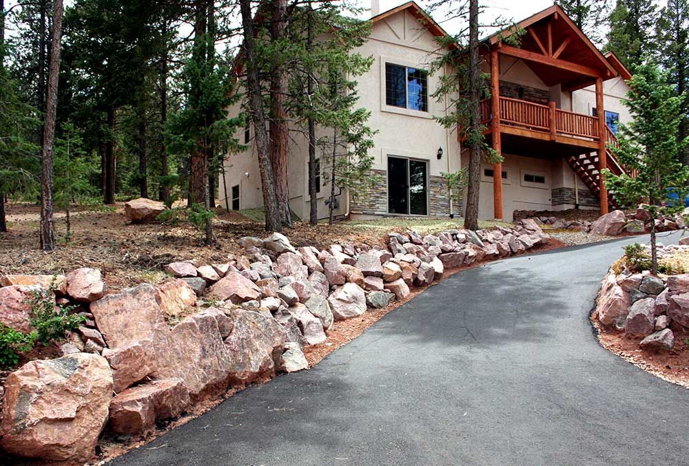A wooden fence with trees and rocks in front of it