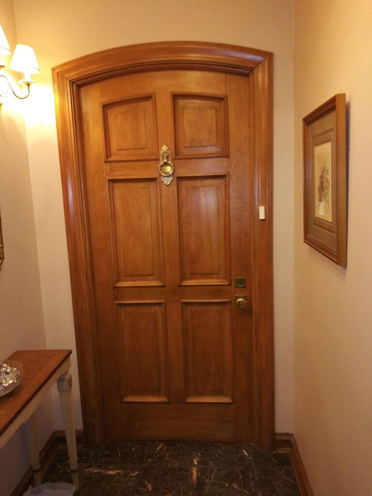 Wood door and decorative frame installation with rounded top and wood stain finish, natural oak wood finish, smooth surface.