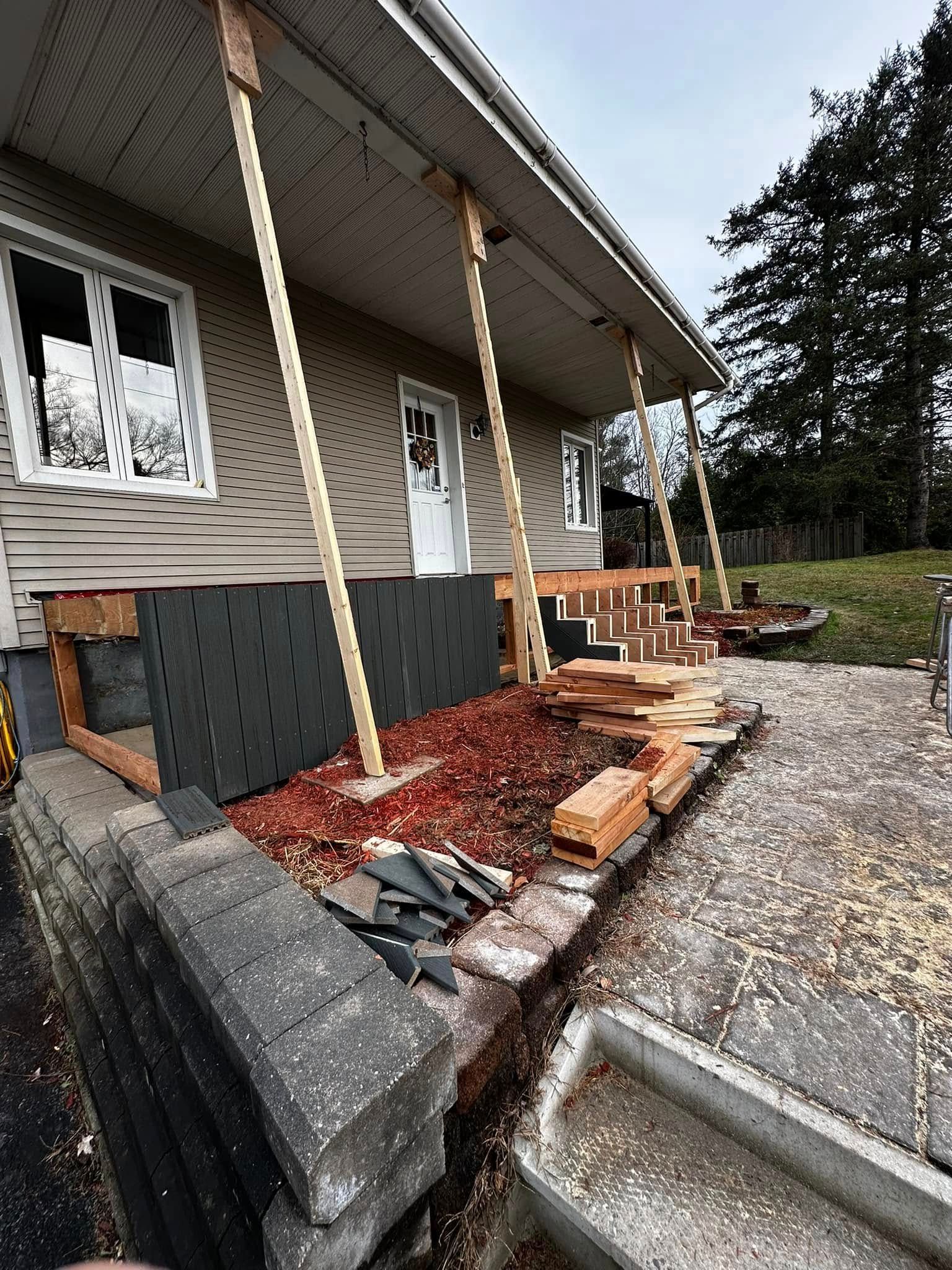 Extérieur de la maison en construction, avec porche, supports en corde, marches et allée de gravier