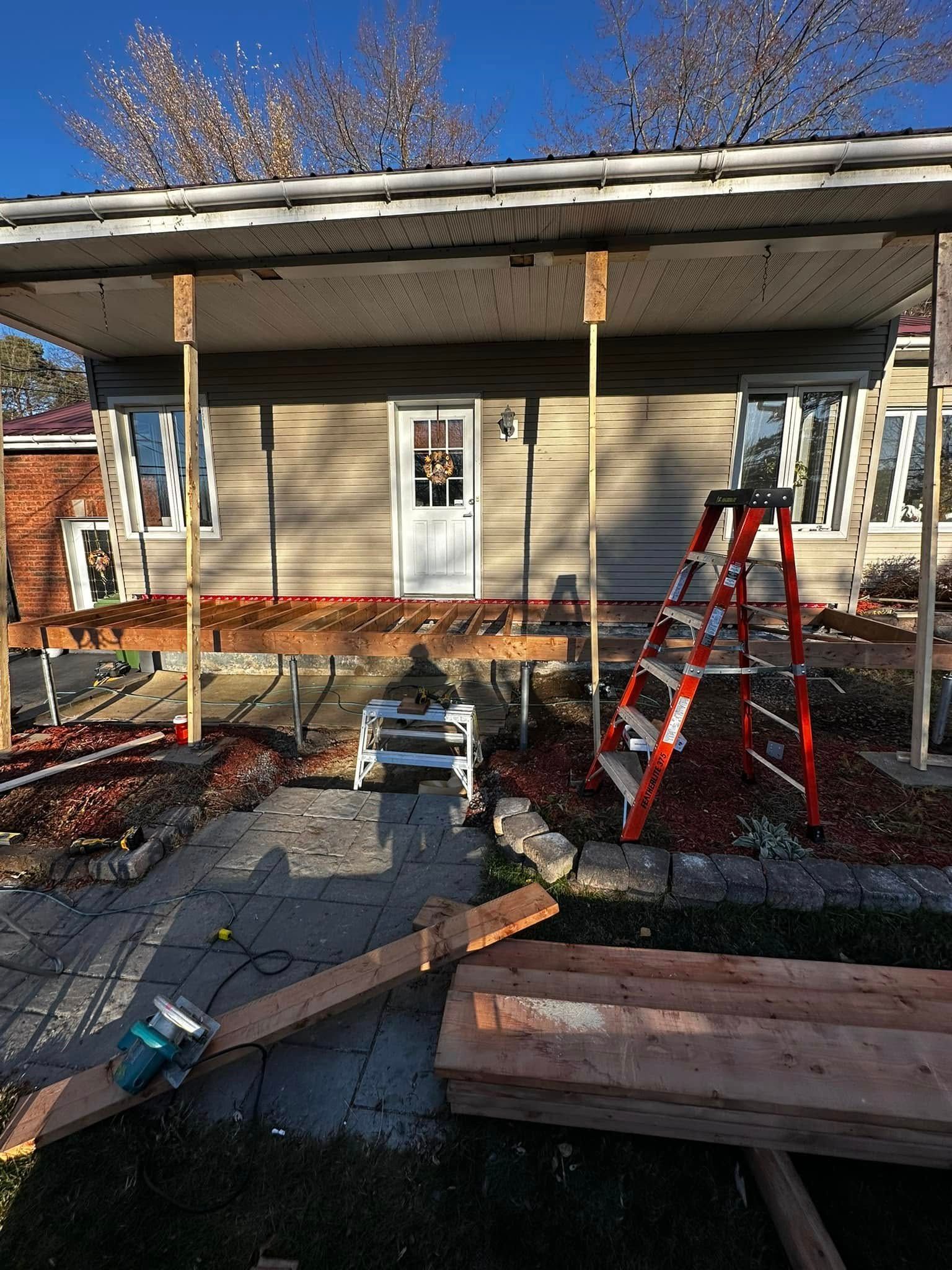 Façade de la maison en rénovation : échelles, échafaudages et débris de construction dans la cour