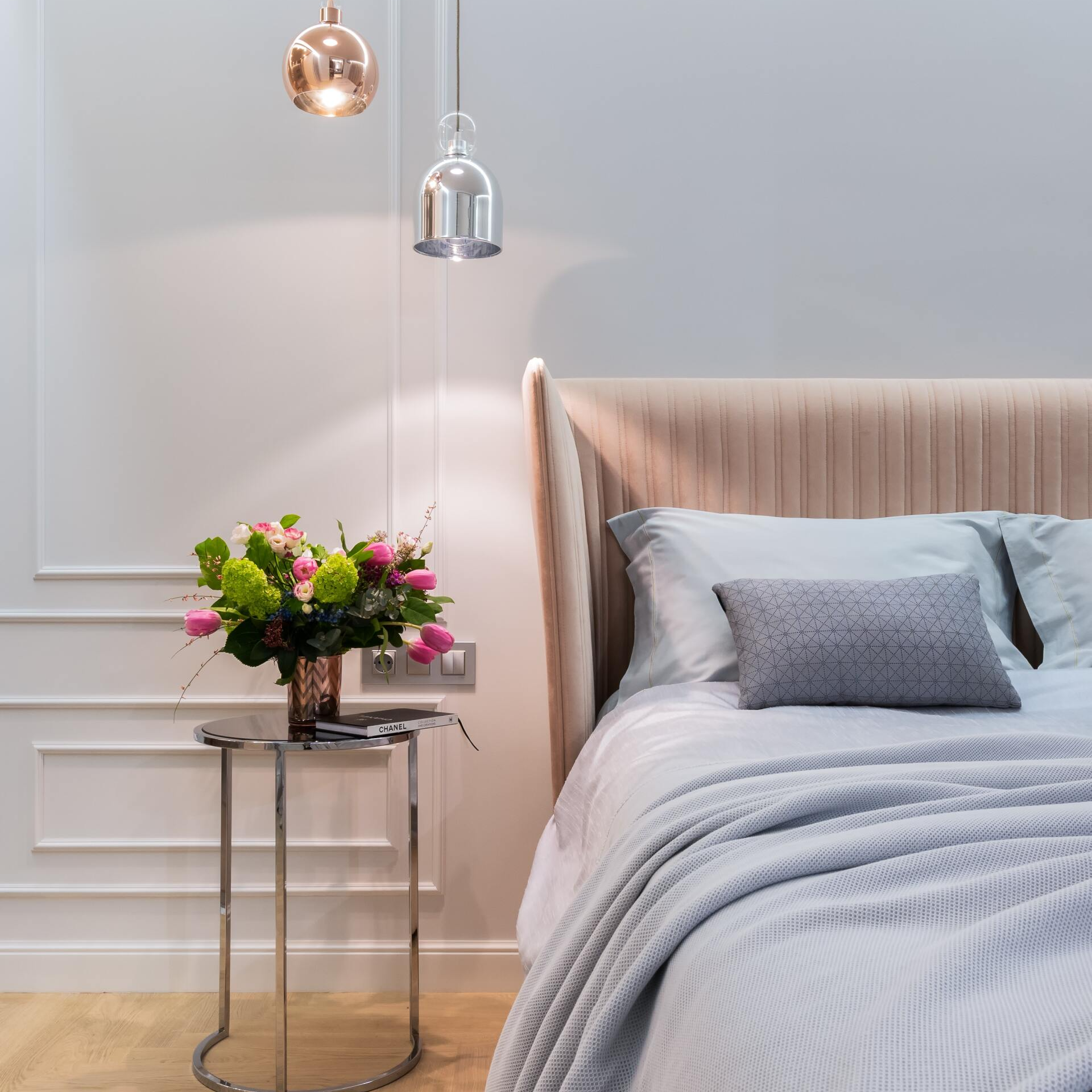 A bedroom with a bed and a table with flowers on it
