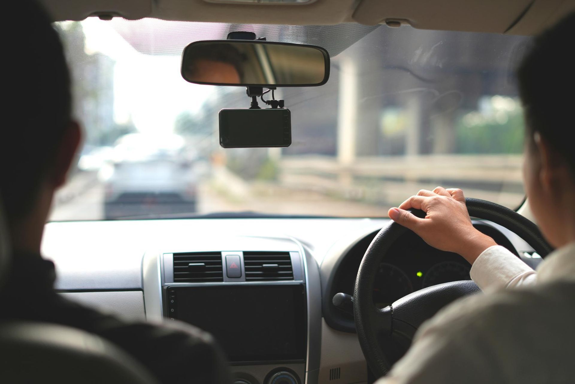 A Man Is Driving a Car with Another Man Sitting in The Back Seat — Greenaway's Taxi in Comboyne, NSW