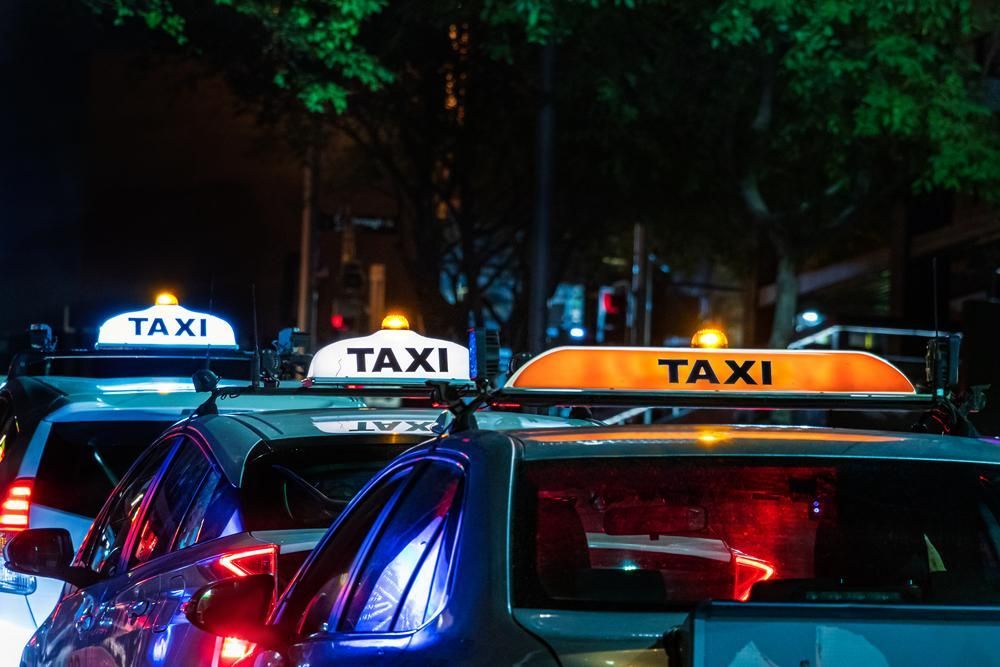 A Row of Taxis Are Parked Next to Each Other on A City Street at Night — Greenaway's Taxi in Wingham, NSW