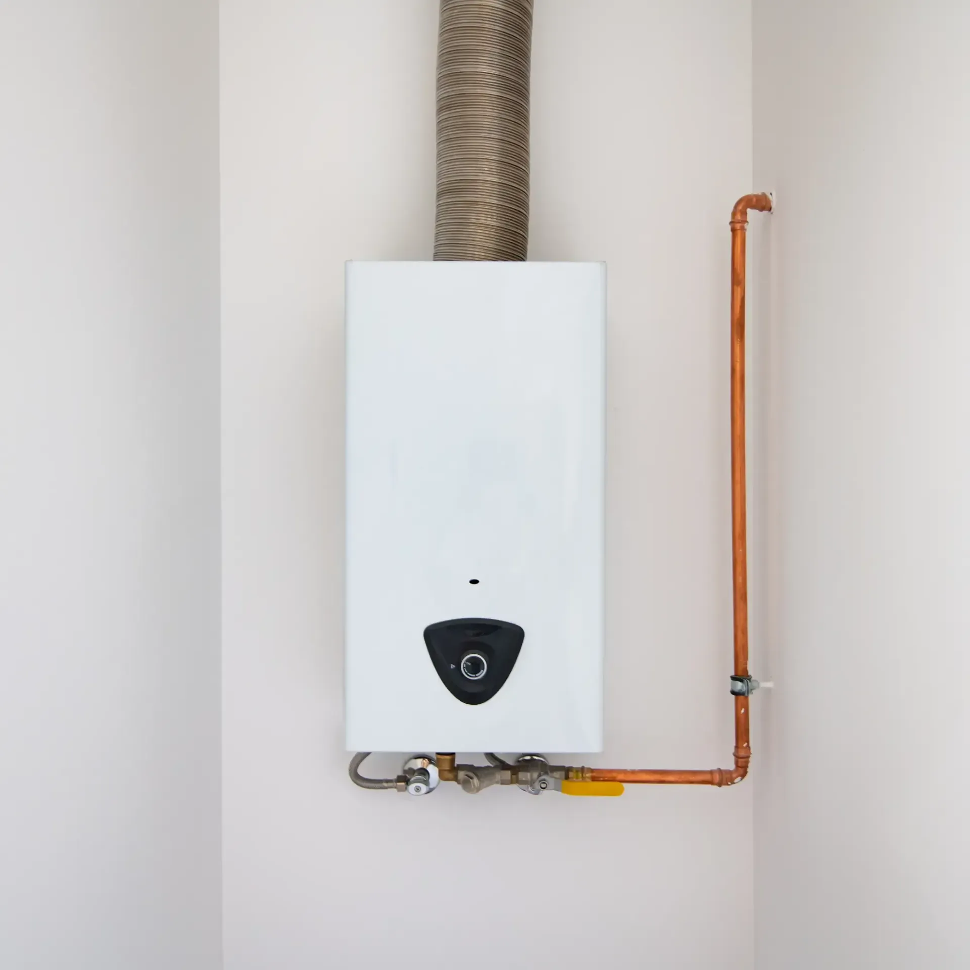 Aarden Air Service Heating & Air Conditioning- A white water heater is hanging on a white wall next to a copper pipe.