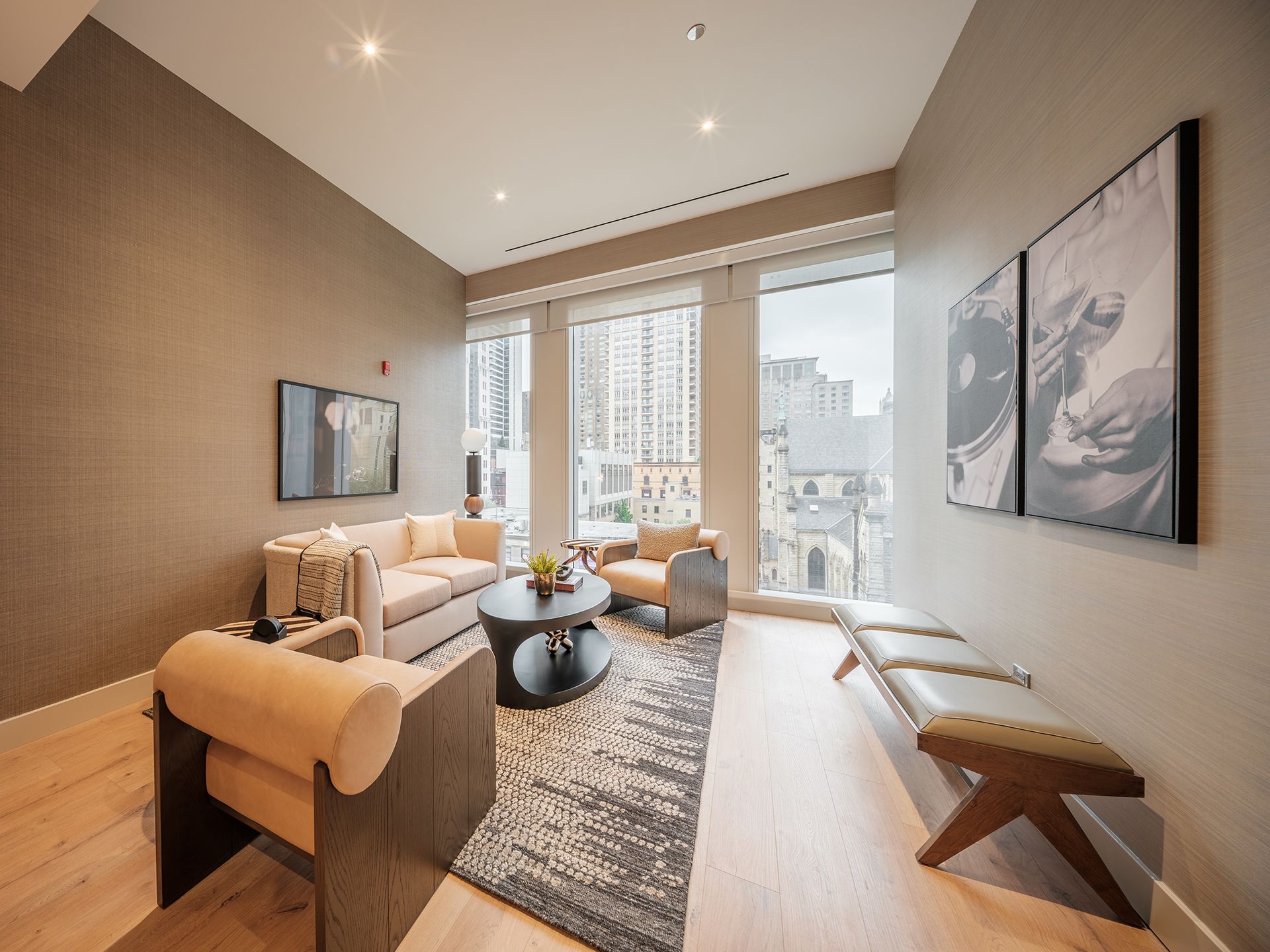 A living room with a couch , chairs , a table and a bench.