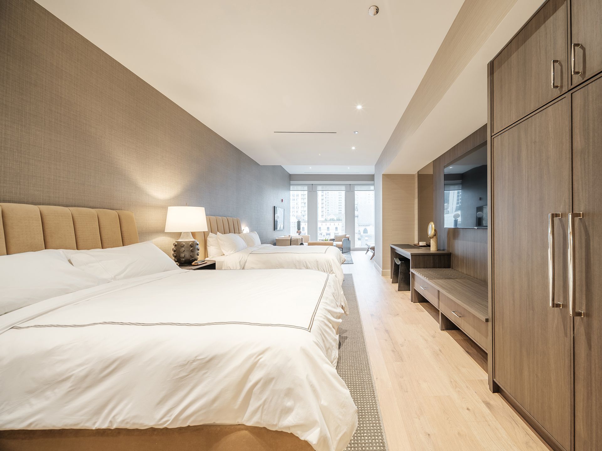 A hotel room with two beds and a large window
