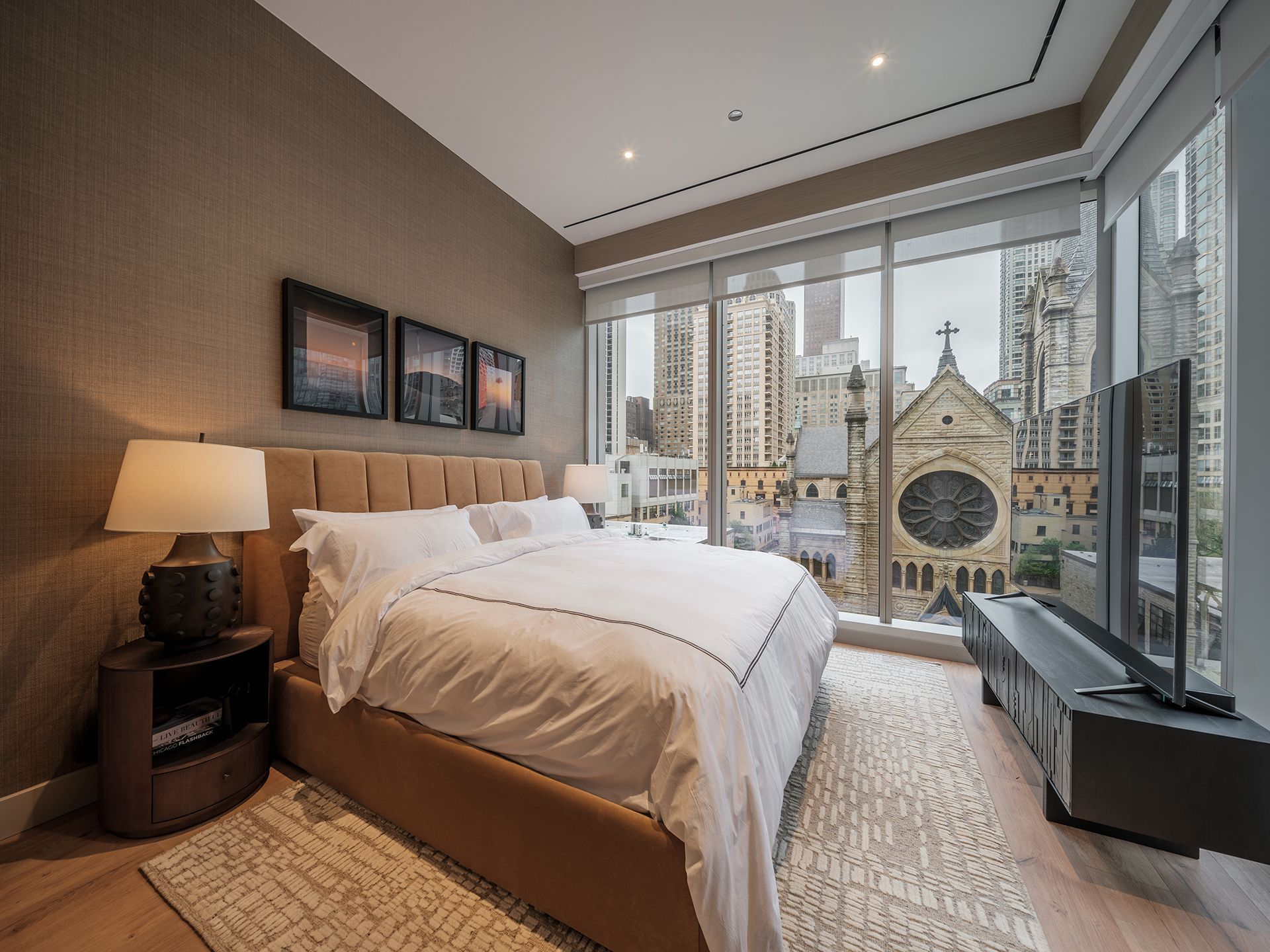 A bedroom with a large bed , lamps , and a television.