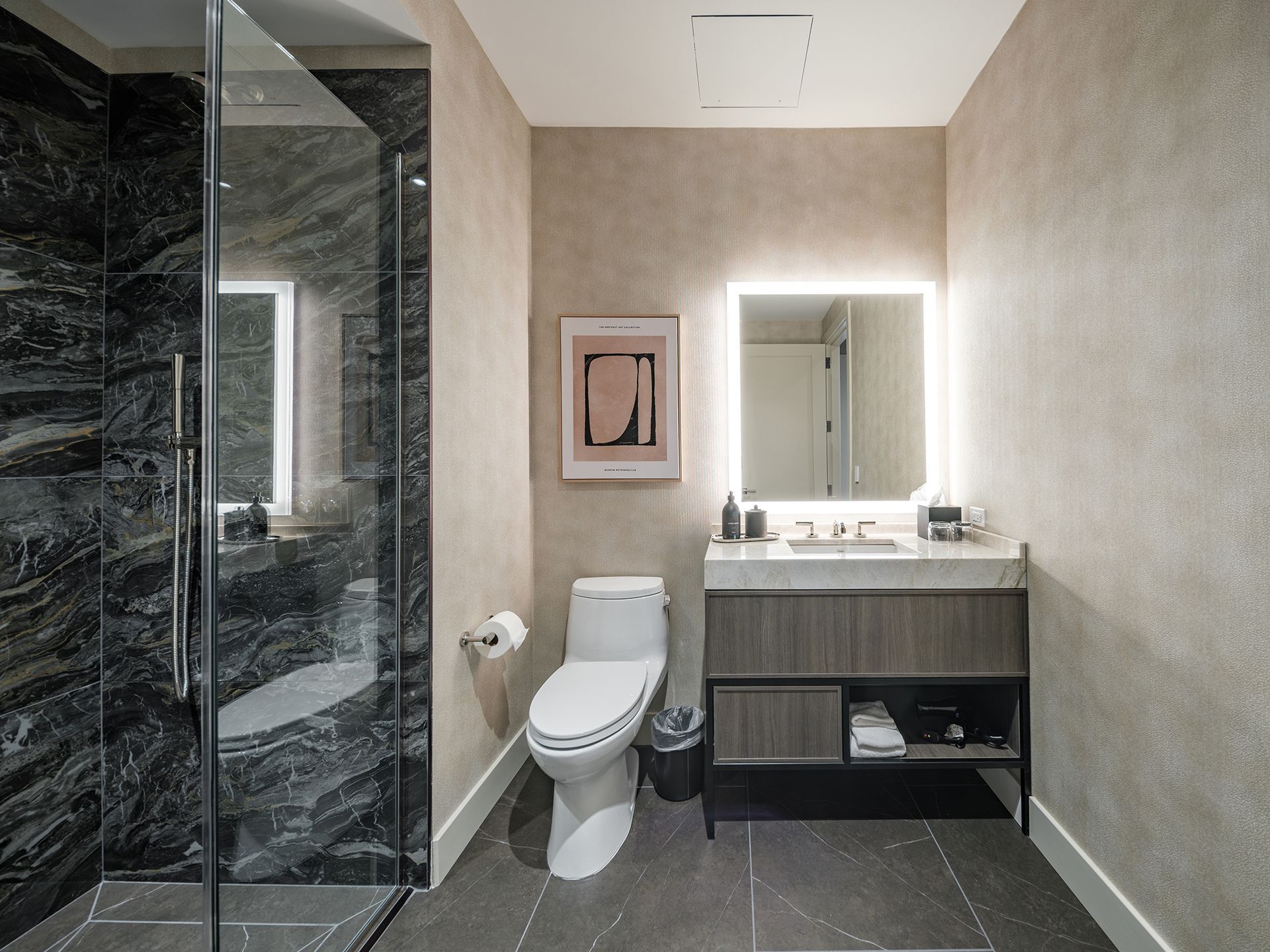A bathroom with a toilet , sink and shower