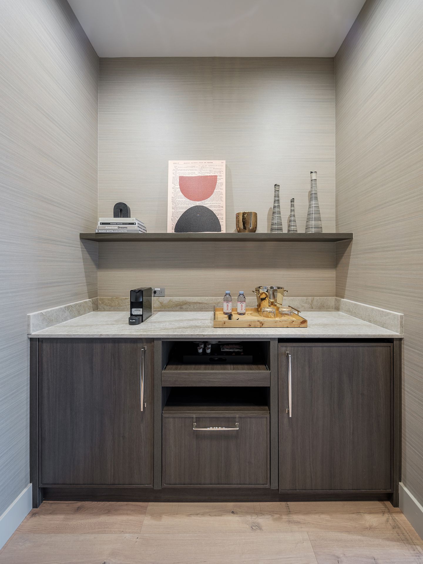 A small kitchen with a marble counter top and wooden cabinets.