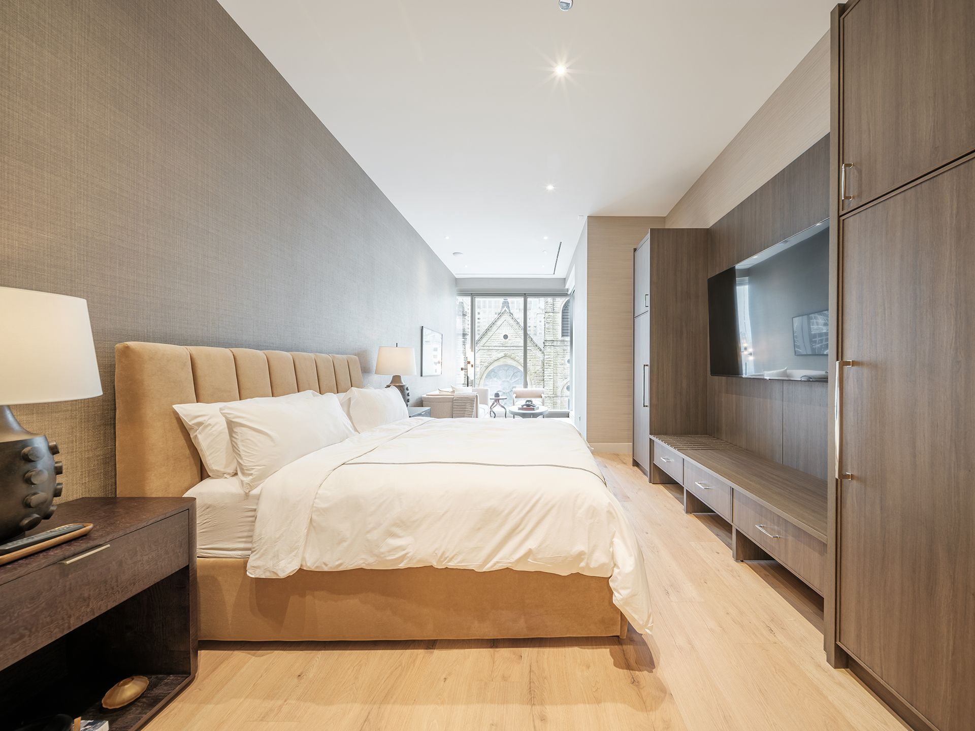 A bedroom with a bed , nightstand , lamp and television.