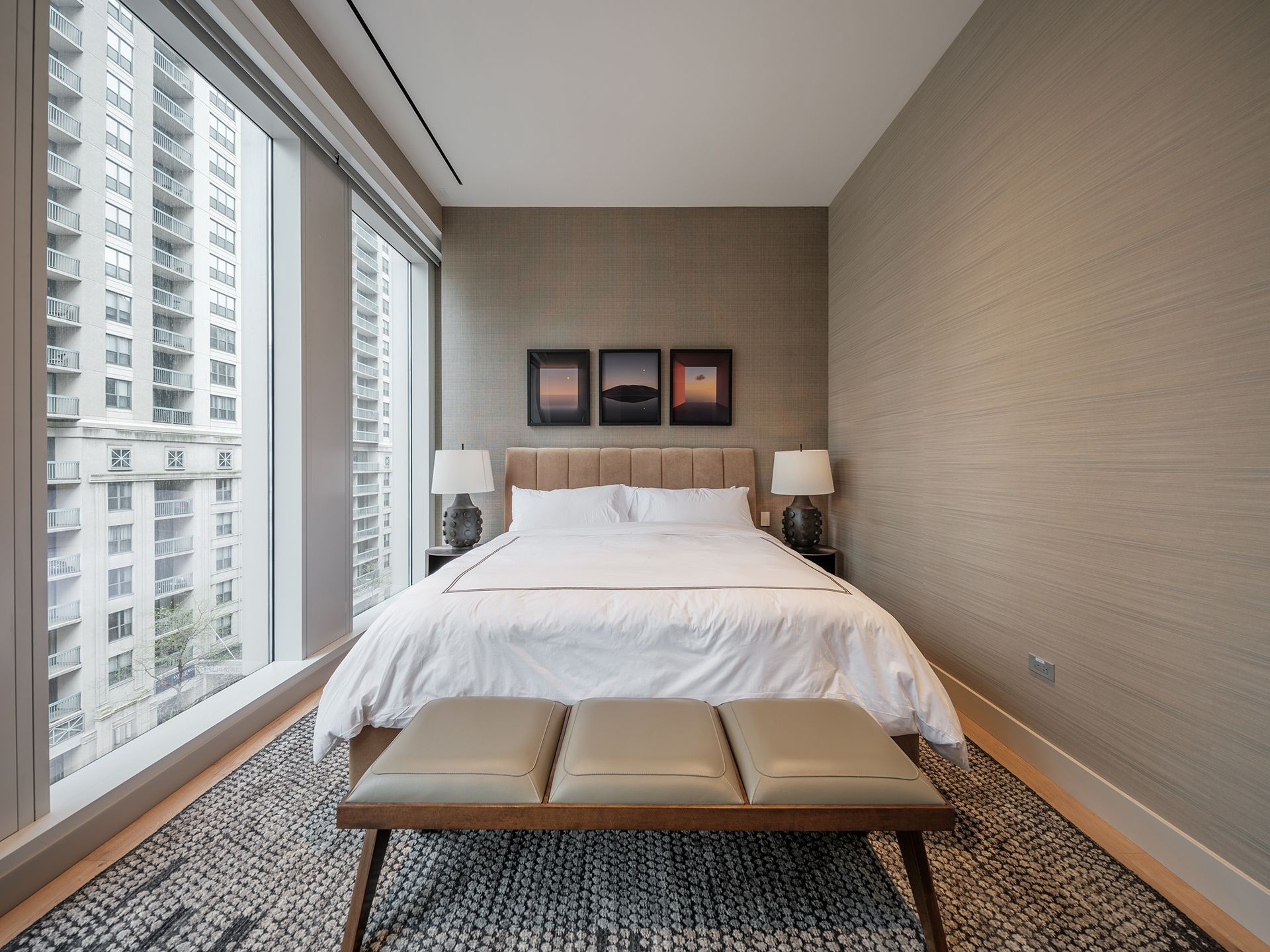 A bedroom with a large bed and a bench in front of it.