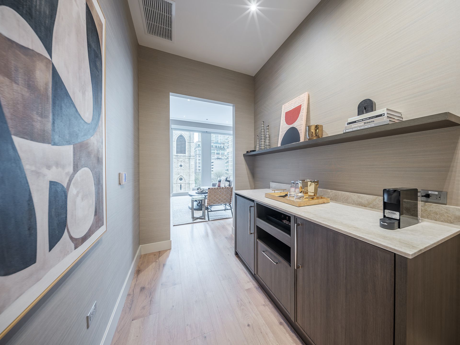 A kitchen with a painting on the wall and a refrigerator.